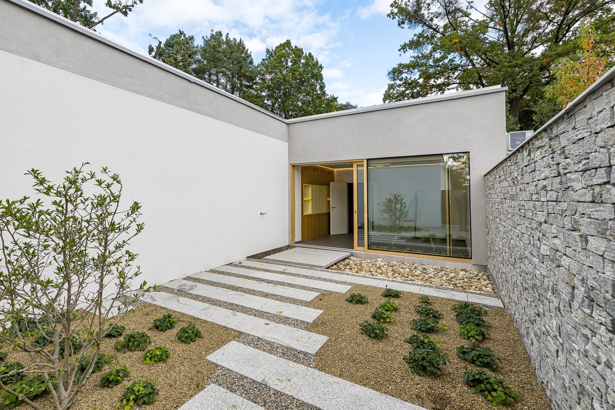 Vstup do pokoje posledního rozloučení s jednoduchou moderní architekturou a klidným okolím.