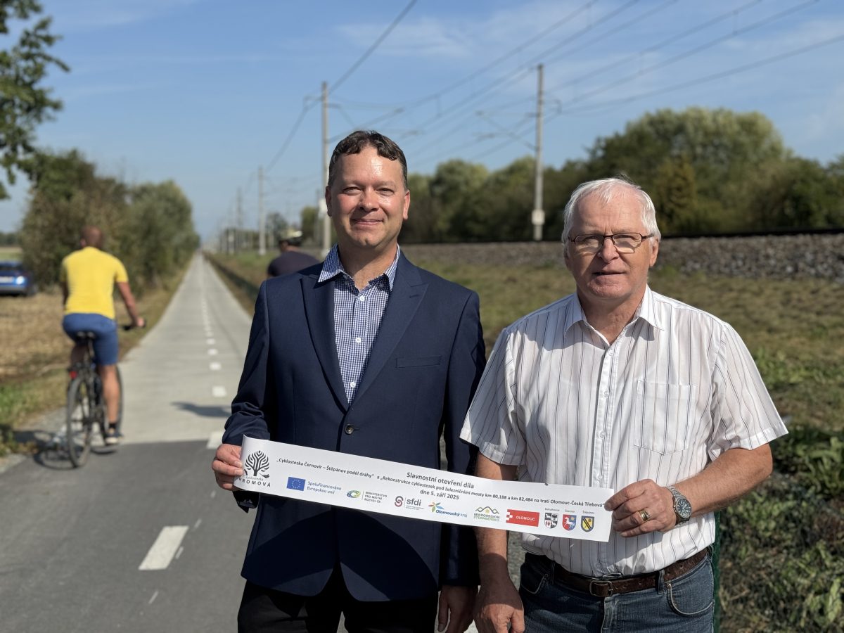 Dva muži drží slavnostní pásku s logy projektových partnerů.