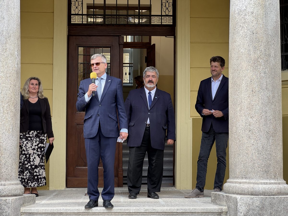Oficiální hosté na schodech před školou při slavnostním proslovu.