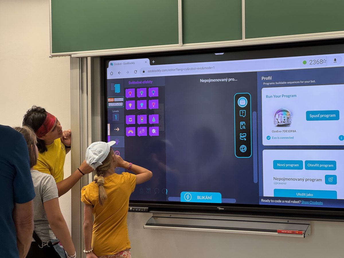 Děti s lektorem u interaktivní tabule při programování robotů ve škole v Chrastavě.