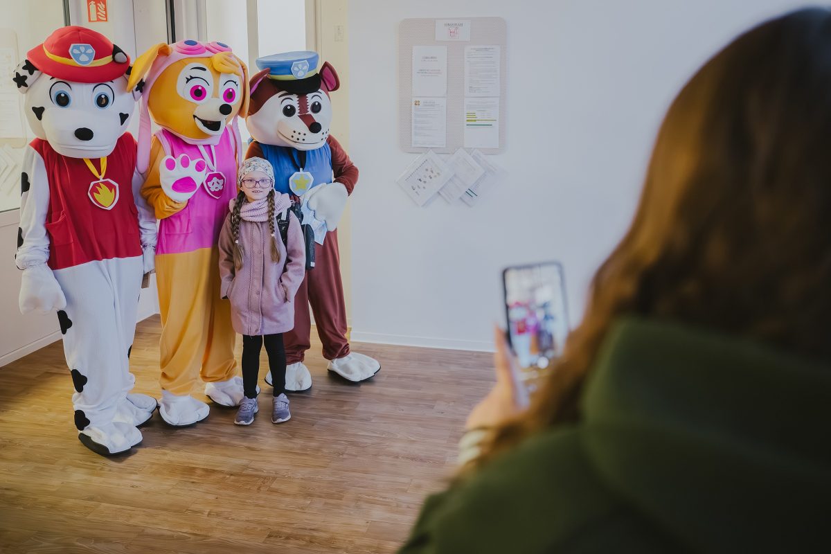 Dítě se fotí s postavičkami z pohádky ve vstupní hale mateřské školy Zavadilka.
