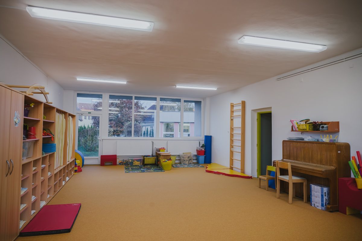 Tělocvična mateřské školy Zavadilka s pianem, cvičebními pomůckami a hračkami.