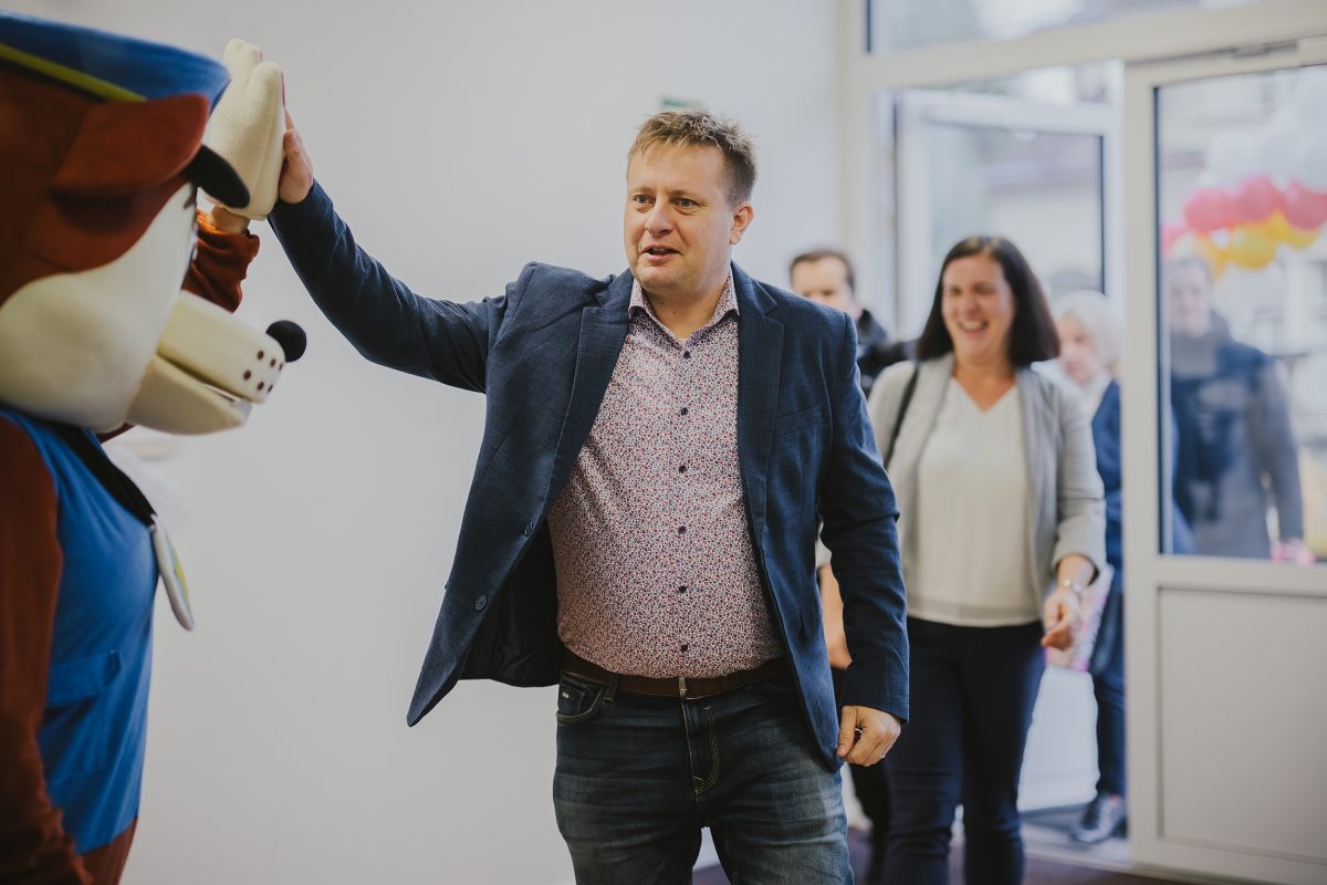 Jakub Řezníček, ředitel královehradecké pobočky CRR, zdraví maskota podáním ruky při příchodu na slavnostní ot