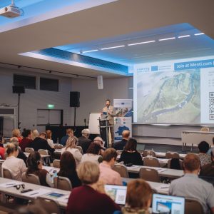 Prezentace a úvodní řečník na pódiu během setkání Interreg Rakousko – Česko 2021–2027 v Brně