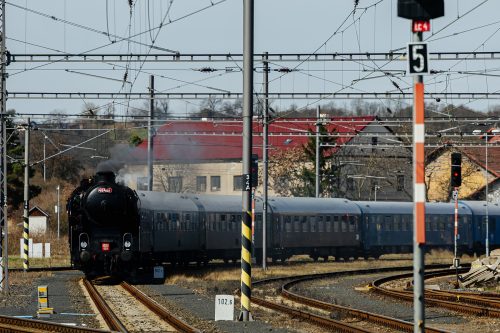 Parní lokomotiva Ušatá projíždí železniční tratí v české krajině